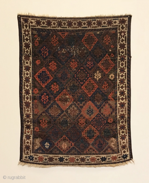 Antique Small Baluch Rug. 4th Quarter 19th Century. Northeast Persia. Rows of diamonds enclose a stepped cross containing birds head motifs. The white ground star border encloses a colorful and lively field  ...