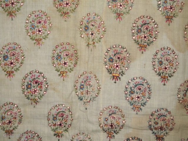 An old Mughal Embroidery, late19th c. Delicately embroidered silk bouquets on fine cotton base.  Complete piece with borders, but stained ground, wear in corners and old repair. Size:63x85cm    