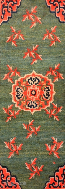 Thick piled natural dyed Tibetan khaden with a central mandala-like motif with leaves spread sparingly about in a lovely marled green main field, which itself has a wonderful abrash. The four corners  ...