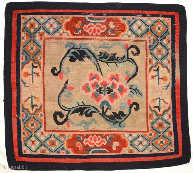 Floral Khagangma seating carpet from Tibet, of a design not often seen. The main field is a simple single flower growing from a trellis like vine. The outermost border is very dark  ...