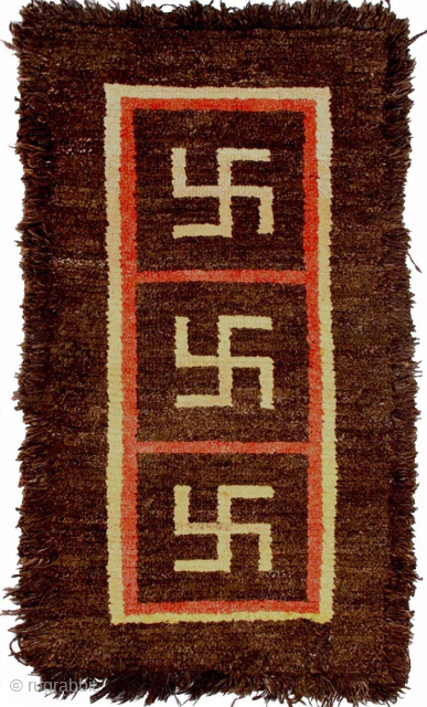 Striking yak wool ‘Wangden-style’ (i.e. warp-faced-back) Tibetan carpet displaying three auspicious yungdrung (swastika) motifs encased within three distinct design squares. It has a very thick natural brown soft yak wool pile and  ...