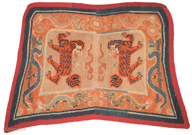 This Tibetan 'butterfly' shaped makden, or under-saddle carpet, features a rare depiction of tigers in place of the snow-lions sometimes seen in the same configuration (on makdens), while sinuous dragons encircle the  ...