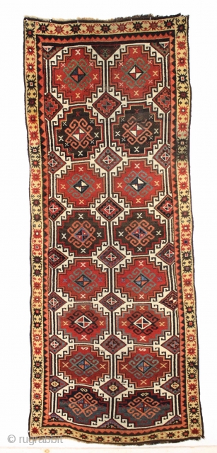 Antique caucasian ivory ground long rug. Complete and original with an unusual border arrangement showing no outer minor border. Original dark wool or goat hair selvages. Nearly black wefting indicating possible Zakataka  ...