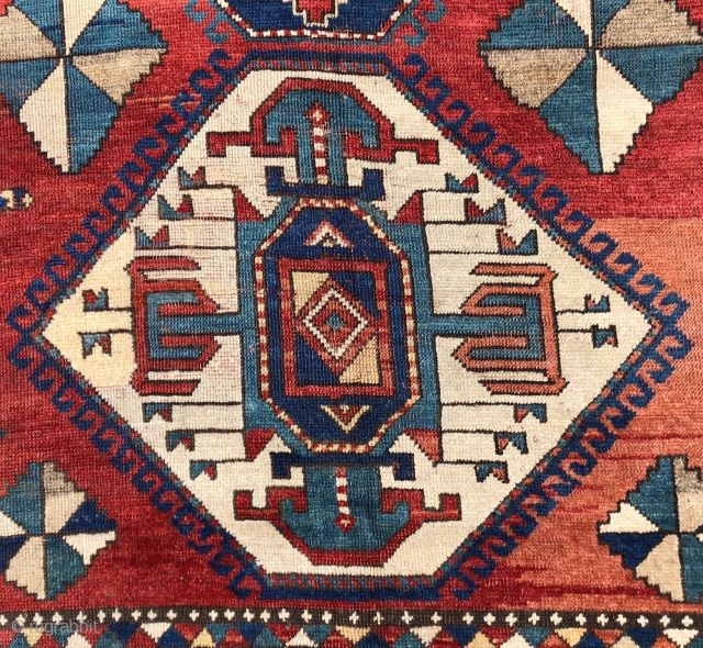 Antique large Kazak rug in fair condition with classic ivory Lori Pombak medallions. Good original natural colors with an abrashed tomato red ground and both light and dark blues. Overall good even  ...