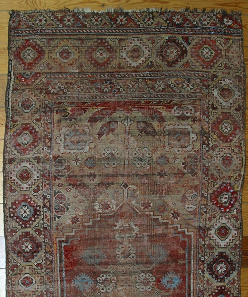 18th century Konya rug,W/W,225x110 cm.
Numerous repilings, inserts, loss of the small lateral outer borders. A unique central axis design that devides the entire field and incorporates the medaillon.     