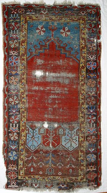 Ladik Prayer rug. Before 1800. 100x200cm, mounted on linen. The great age of this magnificient rug is confirmed, apart from the iconographics, by the colors. The deep stone-red of the 'ocak'( the  ...