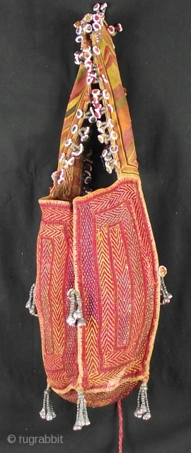 Rabari Bag with four embroidered and tasseled panel sides, each measuring 28cm long x 11cm wide. 
Handle / strap decorated with traditional Rabari bead work flowers 7cm wide x 48cm 
Some wear  ...