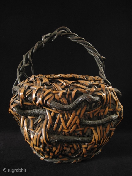 Ikebana basket, Japan.
Nemagaridake bamboo, vines.
12" wide by 15" high (30 by 38 cm).
Pre-1950.                    