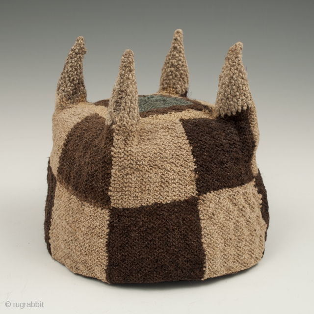 Four-cornered hat, Huari culture, Peru. Camelid fibers, natural dye.
A.D. 700-1000, 5.25" (13.3 cm) high by 5.75" (14.6 cm) diameter.
Ex. Fifi White collection, California. 	

An unusual brown and tan checkerboard four-cornered hat with  ...