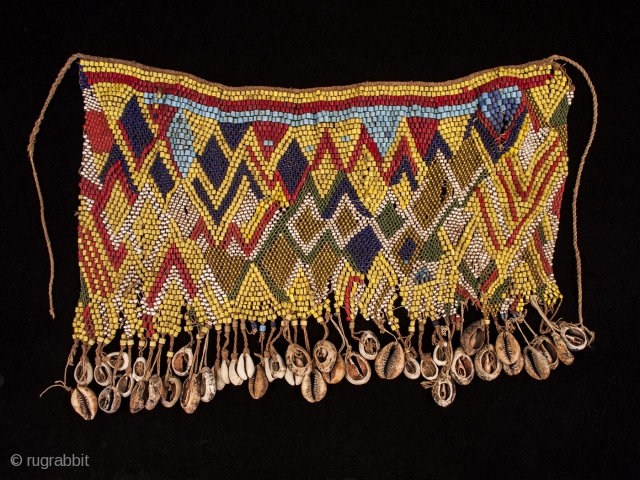 Pikuran (cache-sexe),
Mandara Mountains, Cameroon.
Seed beads, cotton string, cowrie shells, iron bells,
19" (53.3 cm) wide by 9" (23 cm) high.
Mid 20th century. There are a few beads missing here and there, but all  ...