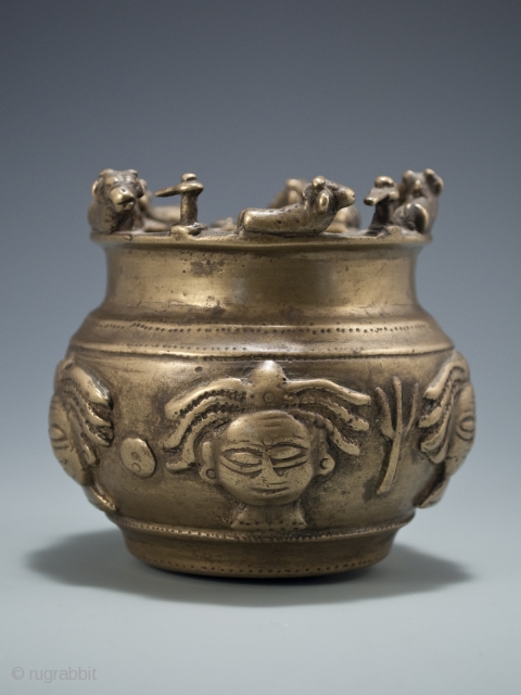 Offering bowl,
Maharashtra Province, India,
Brass,
circa 16th/17th century.
4" (10 cm) high.

This rare Shaivite sacred bowl is adorned with five representations of the dreadlocked Hindu god, Shiva. Alternating the faces are attribute objects of Shiva:  ...