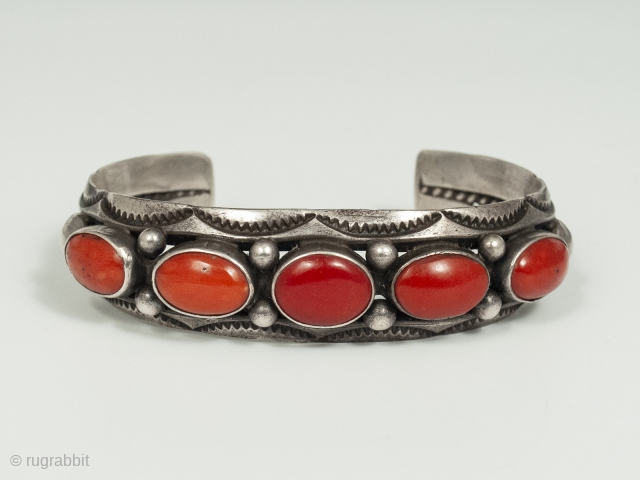 20th Century Coral and Silver Bracelet by Fred Thompson, Navajo Jeweler. Five gorgeous cabochons of rich red coral are set in silver bezels, flanked by silver beads and stamped crescents, in this  ...