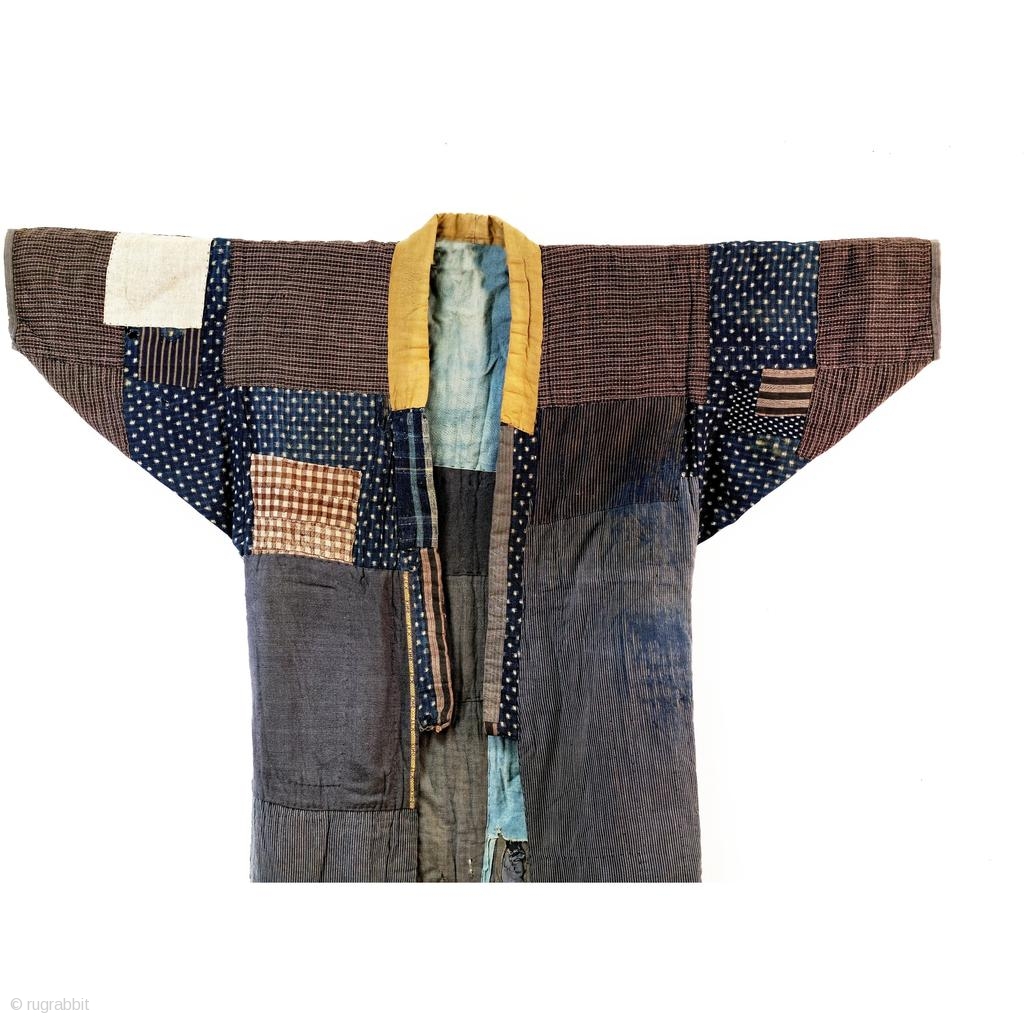 Heavily patched boro noragi displays years of use. Outer jacket shows a ...