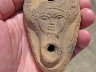 Antique Mediterranean terracotta oil lamp with the face of the goddess Hathor, she is a sky goddess and a counterpart to the male sun deities, so fire in a lamp is appropriate  ...