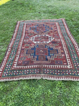 Dirty bashed up Kazak. Couplw of holes, rips and tears bur great colours and design. Ans despite its issues a great rug. Turkish repair special? 7 x 5 feet    