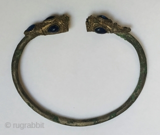 Ancient silver bracelet with lion heads, 2nd-1st century BCE, Near East, inlaid with blue glass, diam. 7.5 cm.               