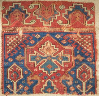 Two fragments of an exceptional 18th century blue-ground Bergama area rug with a curled tendril palmette border. Each approximately 2'6"x2'6".             