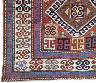 Karachopf Kazak, late 19th century. 74" x 51". a cheerful Kazak featuring a well-drawn ram's horn ivory border framing a red ground with an ivory outlined triple medallion. The ram's horn motif  ...