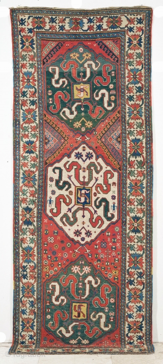 Chondzoresk. "Cloudband" Karabagh Long Rug, second half 19th century, 11ft x 4ft 2in.  This long rug features 3 beautifully drawn medallions on a red ground. The central ivory medallion provides graphic  ...