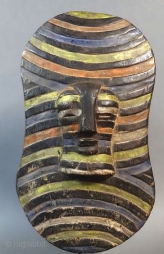 Africa, Congo, Songye tribal group war and dance ceremonial wooden shield. Cm 25x50 ca. Mid 20th. c. With front mask. Polychromatic. In good cond.         