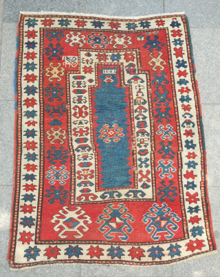 Kazak prayer rug, dated to about 1876. The date is inscribed at the top of the mihrab. 
Note the abstracted beast to the left of the top of the mihrab. Also note  ...