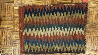 Shasavan Kilim Bagface -zig-zags-, ca.1870; 1’8” x 2’0”/ 51 x 62 cm. rows of zig-zag stripes in rust red, indigo, green, ivory, teal, goldenrod, and aubergine. Slight traces of fold lines.
  