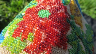 Exquisite micro beading to this purse made over 100 years ago, probably in France.Tiny beads, arranged to depict a wonderful assortment of flowers: roses, pansies, marigolds and Morning Glory in a broad  ...