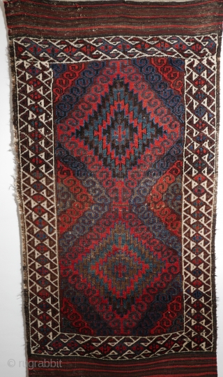 Mushwani Belouch/Baluch,  circa 1900,  2'10"x5'6",  wild and beautiful, with vivid red,  blue,  aubergine and white;  symmetrically knotted; kilim ends are complete except for small rough spot  ...