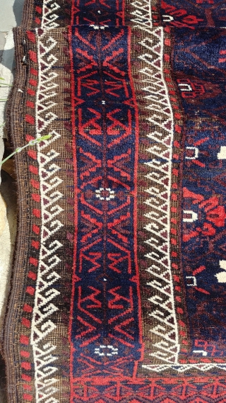 Antique Mina Khani Baluch. 254cm x 90 cm (8'3" x 3') Cherry red and deep navy blue. Unusual borders with long knotted elems.  Camel wefts.  Corroded blacks in the border.  ...