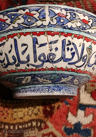 Old Turkish (Iznik?) bowl with calligraphic inscription.  Diameter 8.25 inches, 3.75 inches tall.  A crack and minor nick with old repair. Intact and stable,  Shows beautifully though fragile.   ...