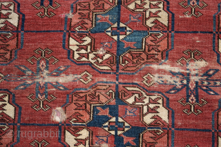 Early Tekke Main Carpet. with areas of wear, holes and a cut. 294cm x 206cm                  