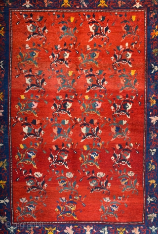 South Caucasian Karabagh Rug. In the Red field, short stems arranged in parallel rows combine into a dense repeat in shades of green, red and pink. Each stem bears a large blossom.  ...