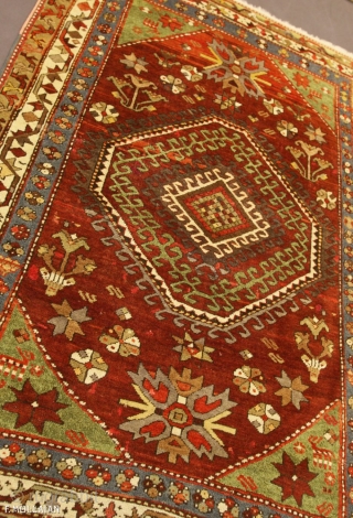 A fine Kazak rug, South Caucasus.

The abrashed deep rust field with various angular floral motifs and hooked panels around double hooked octagon medallions containing hooked bars, Green stellar flower head and animal  ...