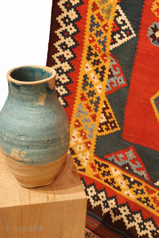 An exquisitely woven antique Qashqai kilim from southwest Iran. The central motifs, the emblem of the Qashqai tribe, is beautifully repeated across the rich terracotta field. The color transitions diagonally, creating a  ...