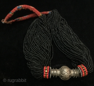 Tribal antique woman necklace from Indus
kohistan valley of Pakistan. The central large bead is silver
while the numerous strands of black beads are glass beads.         