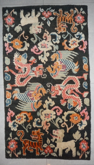 old tibetan khaden showing together the most popular motifs since the late 19th c. as dragon, tiger, lion and rarer seen on rugs garuda. 
according to a probably first third 20th c  ...