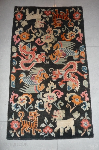 old tibetan khaden showing together the most popular motifs since the late 19th c. as dragon, tiger, lion and rarer seen on rugs garuda. 
according to a probably first third 20th c  ...