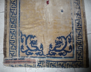 early foliated dragon fragment from a great 17th c ningxia rug. this fragment shows the original length of the piece but has been reduced in width. bad condition around the dragons. china. 