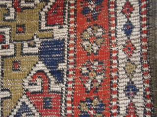 An East Anatolian village rug, (7.6ft x 3.5ft.) with distinctive Caucasian characteristics with a Kuba-Konagkend stepped medallion, framed by a stylised bird border. Two amulet motifs placed a-symmetrically at each end. Around  ...