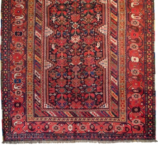 A beautifully drawn antique Khamseh long carpet from the tribes of South Iran. The blue ground has many interesting characters. It is scattered with stylised bushes, flower heads, women and chicken amongst  ...