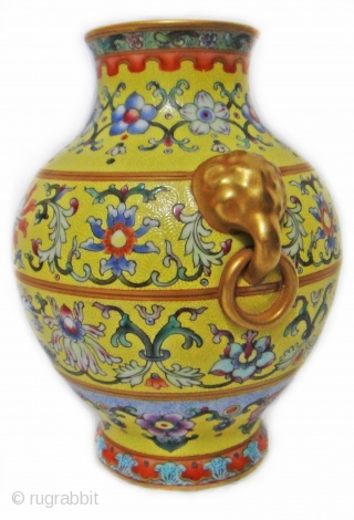 An important and very rare yellow-ground famille rose vase. iron-blue six-character sealmark and of the period (1796-1820)The vase of compressed pear-shape, elaborately decorated with four large blossoming lotus evenly spaced around the  ...