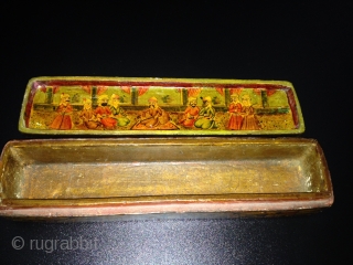 A POLYCHROME LACQUER PAPIER MÂCHÉ PEN CASE (QALAMDAN) QAJAR IRAN, 19TH CENTURY
With rounded ends and sliding tray, the top painted with a central cartouche depicting Nasir al-Din Shah with Persian poems enthroned  ...