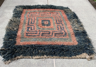 Quite rare and powerful monastic Tibetan seat rug with a square central symbol that shrinks in five steps to the centre. A running dog variant as a border. I would date the  ...