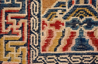 Above-saddle carpet woven in the Ningxia region of China in the early 1900’s. The main border consist of interlinked swastikas, while the inner border features a single key meander. At either end  ...