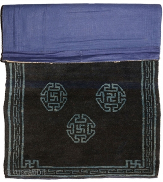 Very attractive Tibetan blue seating carpet with seven small mandala-like ‘medallions’ floating in the main field, each enclosing an auspicious swastika or sauswastika (i.e. a reverse swastika), with a 'T' shaped meander  ...