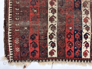 Early Baluch rug with interesting and archaic striped or “cane” design. Overall very rough with areas of foundation exposed and no pile. All natural colors including an excellent saturated red. Remnant original  ...