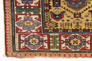 antique mustard yellow ground caucasian rug in good condition. Serrated lattice with large tulip palmettes and an unusually colorful wide ivory kufic main border. Overall nice even medium pile with slight brown  ...