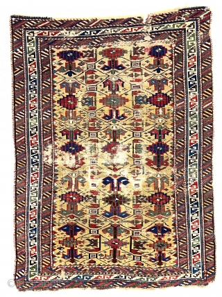 Antique little yellow ground Caucasian kuba rug with an archaic overall lattice design. Pile varies from decent low to very low in spots with some foundation showing. Minor edge loss all around.  ...