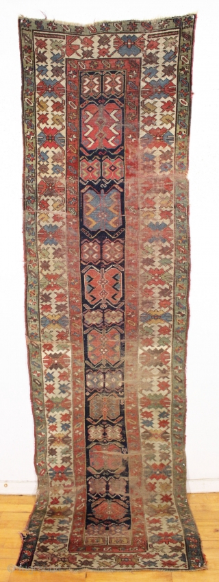 antique long rug, probably nw persian, with an interesting archaic design and older all natural colors. Note the area of white cotton pile seen clearly in back pic. In abused condition, very  ...