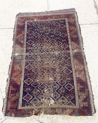 Antique Baluch rug with an uncommon “c gul” field. Acquired many years ago from a well known Providence collector. Not in great condition, holes and wear, but has presence. 19th c. 43”  ...